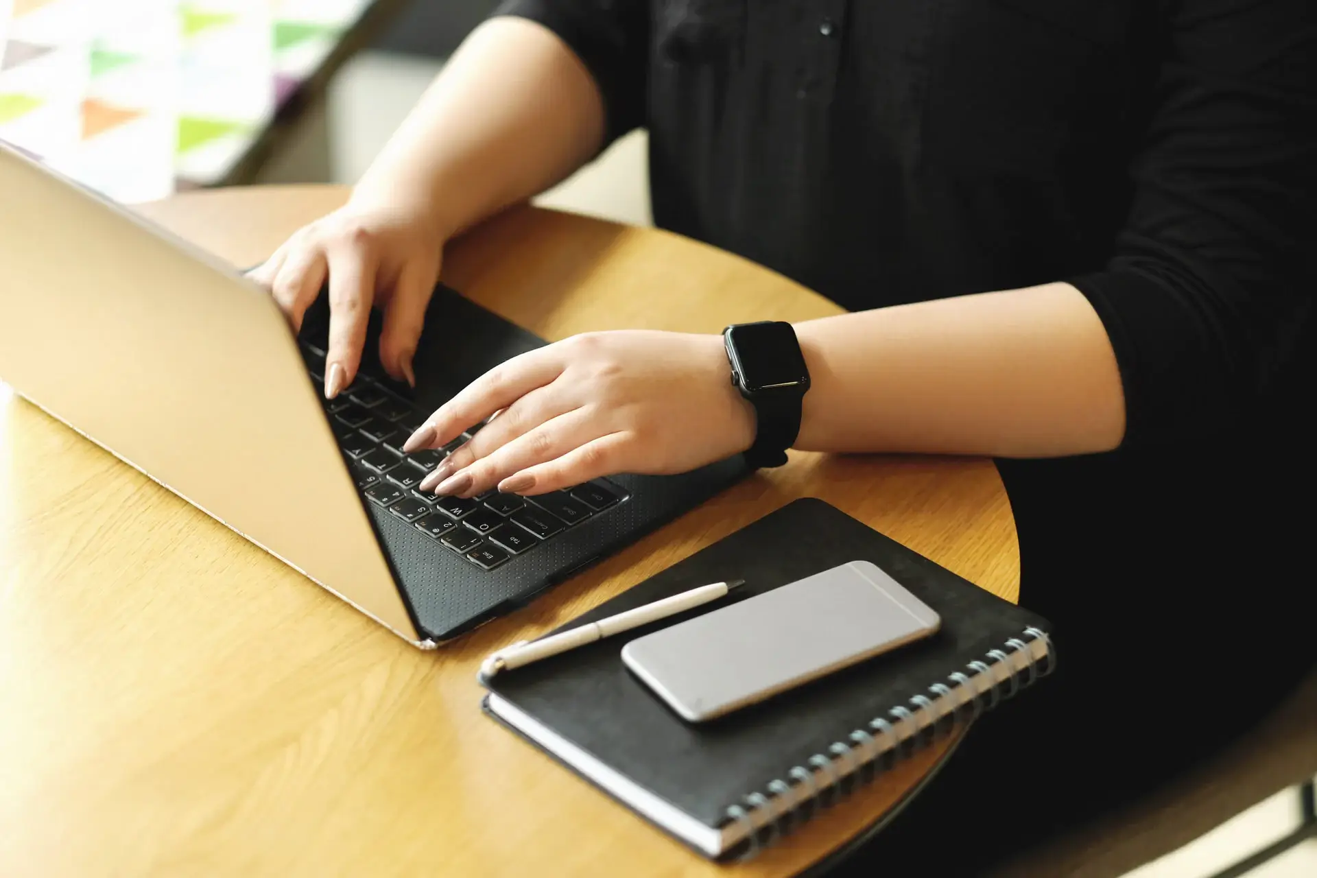 an image depicting a woman typing at a laptop